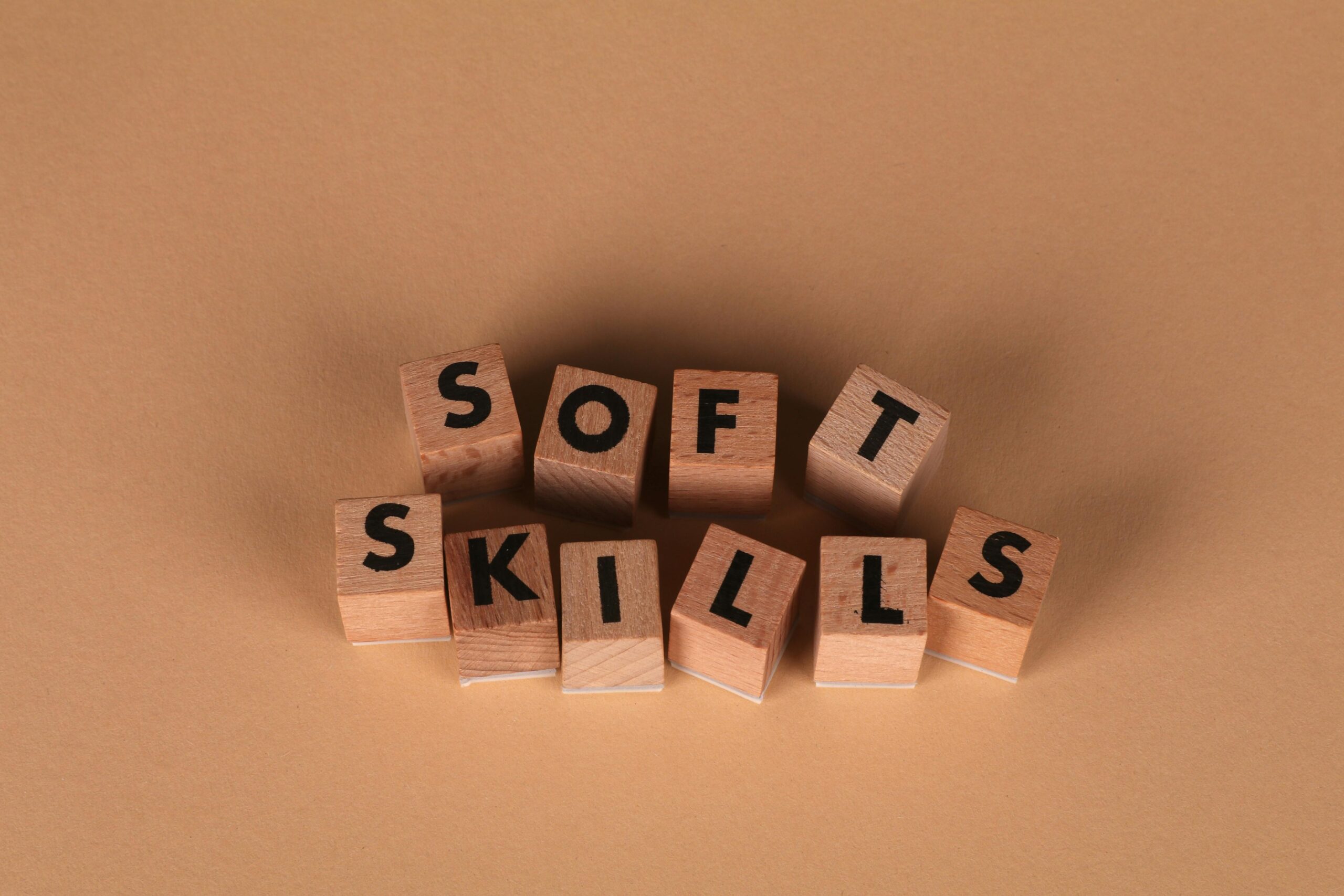 Wooden letter blocks spell out 'Soft Skills', highlighting business and personal development concepts.